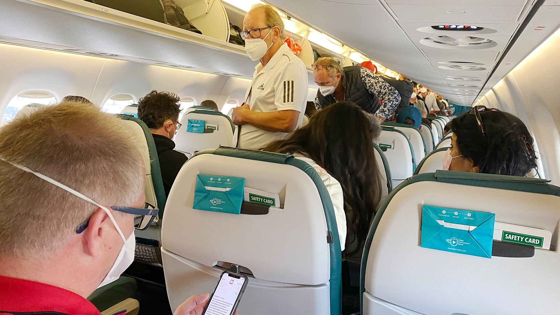 Passagiere mit Schutzmasken betreten ein Flugzeug. | picture alliance / SVEN SIMON/Fr